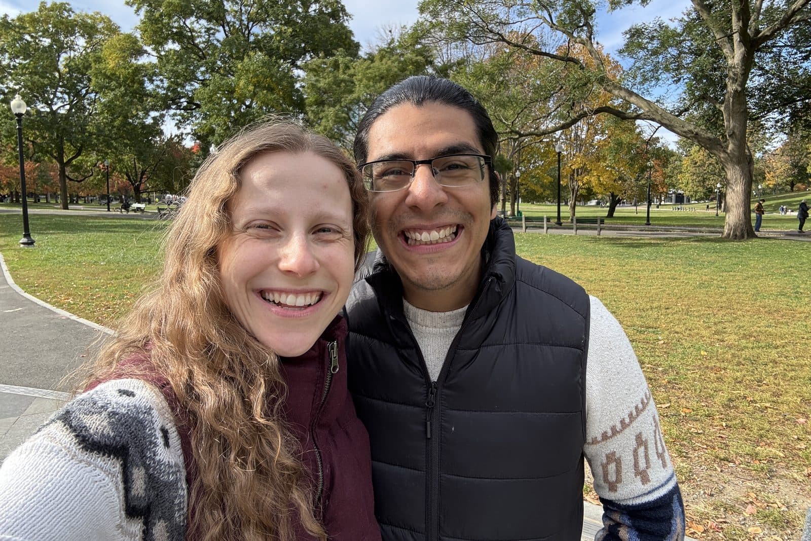 Danah and Joe Meyer, smiling together in a park on an autumn day.